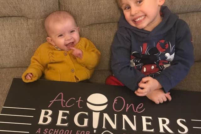 Leanne's two children, Autumn and Kobi, with the banner for her new theatre school.
