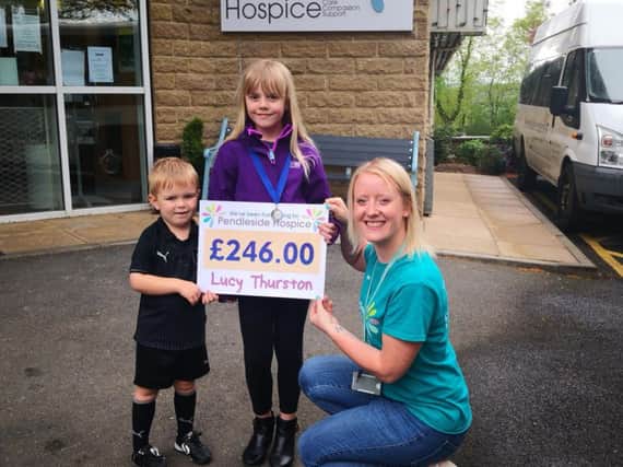 Lucy and her little brother present a cheque for 246 Lucy made from selling sweet cones, to hospice fund raiser Leah Hutchinson.