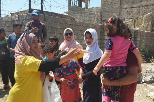 Humeira Bibi handing out supplies to try and bring a smile to the faces of the needy