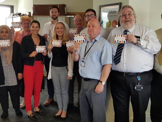 Staff from The Calico Group holding postcards promoting Safe Leave to employees