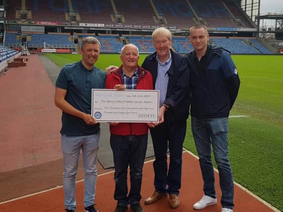 Barry Kilby receives a cheque from Anthony and Tony Carter and Ryan Strange
