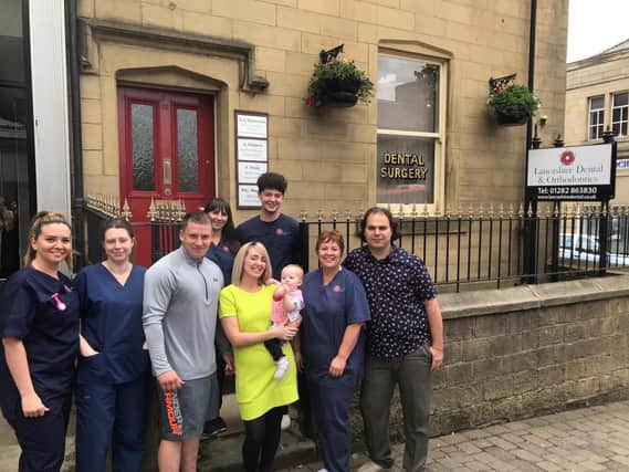 Jason and Julie pictured with staff at the Albert House Dental Practice in Colne who were the heroes of the hour when their baby daughter Larosa collapsed while on routine visit.