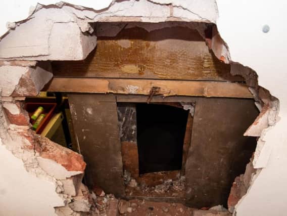 The  gaping hole in the wall and the safe with its back drilled off after the raid at Burnley Auctioneers