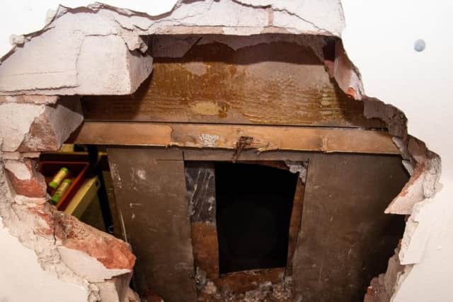 The  gaping hole in the wall and the safe with its back drilled off after the raid at Burnley Auctioneers