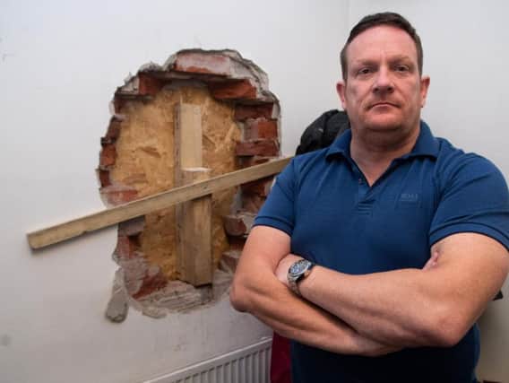 Lee Bradshaw next to one of the walls that raiders drilled through at Burnley Auctioneers.