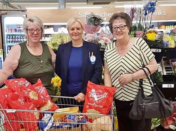 Billie Jean Horne of Tesco, Burnley, presents Karen Heseltine (left) and Margaret Unsworth of Burnley Wood Community Centre, with a trolley packed with groceries for the summer playscheme.