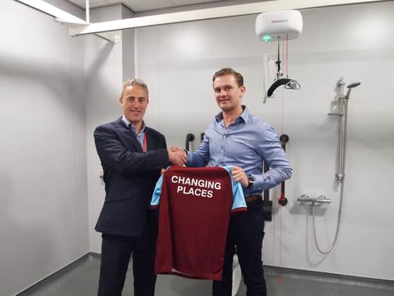 Projects Director Bob Oliver (right) handing over a Changing Places football shirt to Burnley's Stadium and Operations Manager Doug Metcalfe.