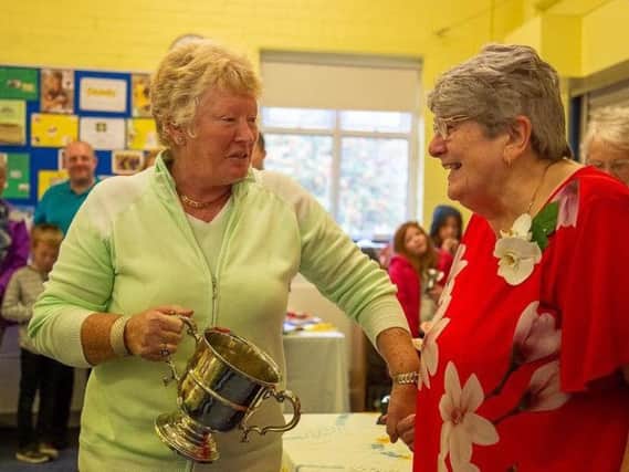 Catherine Briggs (left) receives one of her many trophies from Marie Heys  at Cliviger Flower Show.