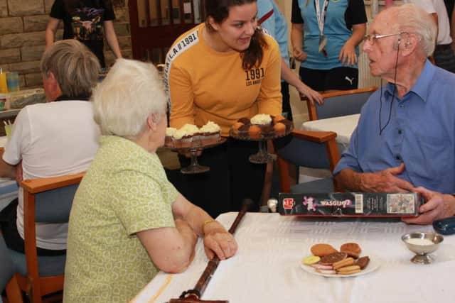 Courtney Ferdenzi serves visitors at the coffee morning
