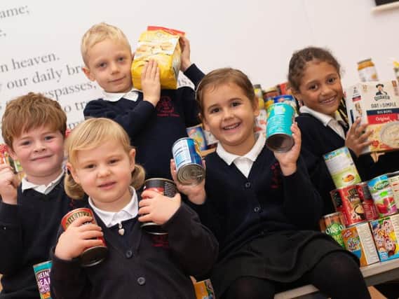 Some of the pupils at St Augustine's RC Primary School in Burnley with the items donated by parents as part of World Food Day. (Photo by Andy Ford)