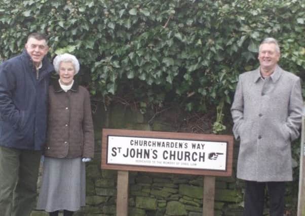 The sign erected in memory of Mr Cyril Law, with his widow Joyce and son John, and local resident Mr Joe Tomkinson, who first suggested the sign.