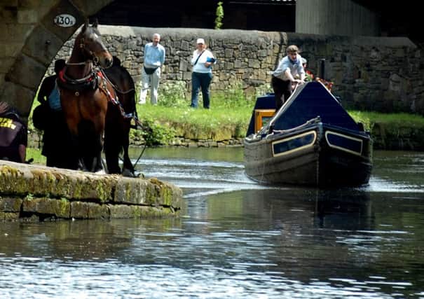 Horse drawn barge is pulled along the banks of Leeds Liverpool Canal. Pictured at Burnley Wharf.