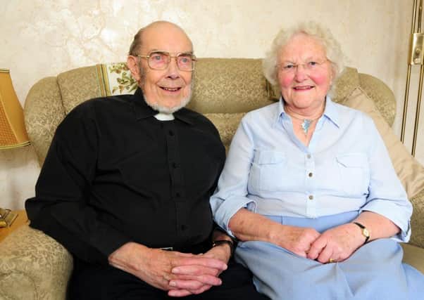 Rev. Ian Robins who is celebrating 60 years in the Church of England priesthood pictured at home with his Gertrude.
Photo Ben Parsons