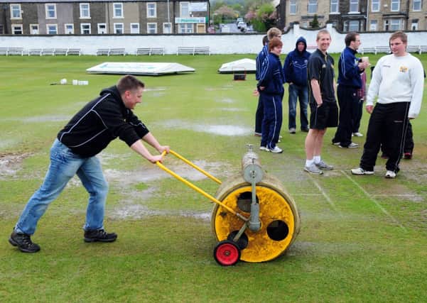 Players and ground staff at Read Cricket Club fight a losing battle against the rain
