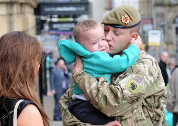 Nathan Lindsay (21) is greeted by his son, Riley and girlfriend Naomi (20) on the steps of Burnley town hall during the homecoming parade.