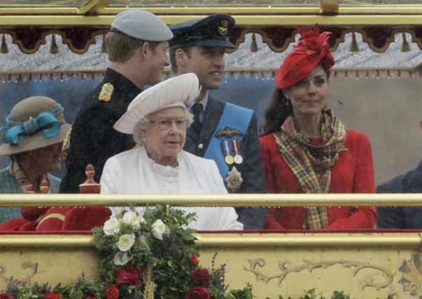 Prince Harry (left) the Duke and  Duchess of Cambridge and Queen Elizabeth II, look on from the Royal Barge, during the Diamond Jubilee River Pageant on the River Thames, London.
