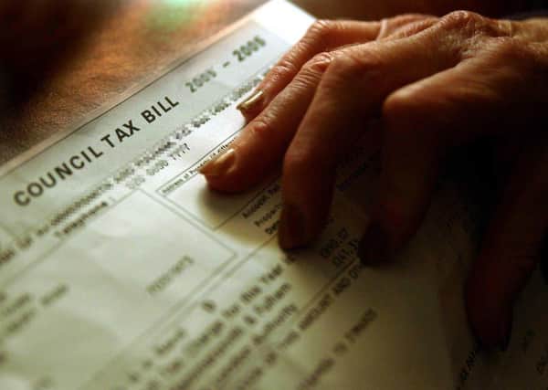 A pensioner examines her council tax bill. Photo: Chris Young/PA