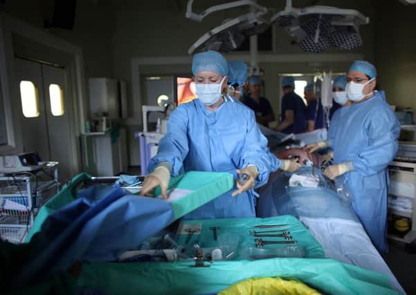 A surgeon and his theatre team perform key hole surgery.  (Photo by Christopher Furlong/Getty Images)