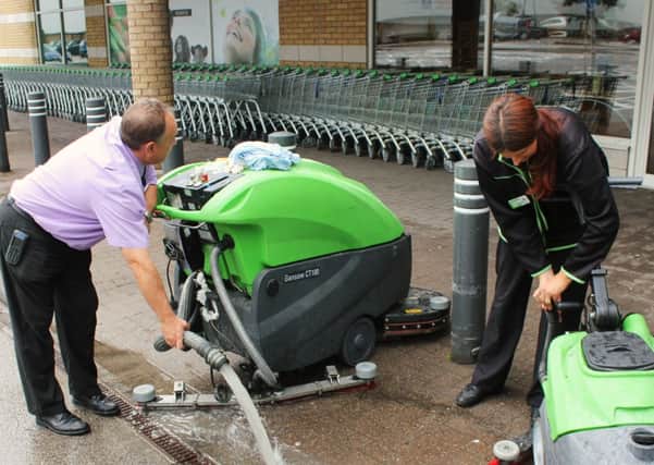 Staff pumping water out of the flooded Colne Asda Store.
