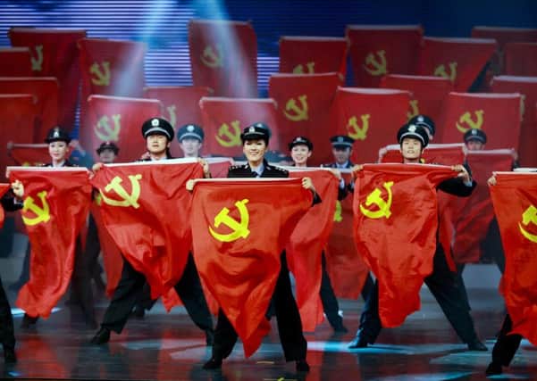 Civil servants of the provincial government perform on stage with Communist flags in a gala event to celebrate the upcoming 18th national congress of the Communist Party of China. (AP Photo)