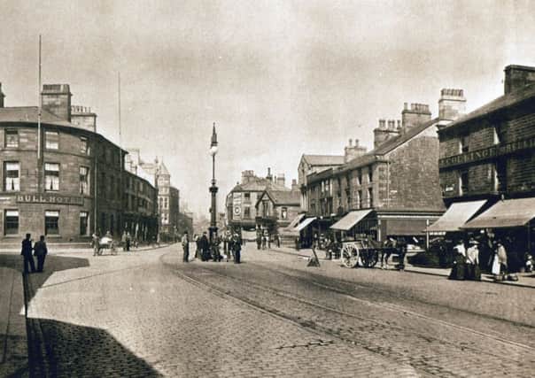 St James's Street in the new town centre. This part of town became the new town centre in the late 18th Century with the market held in the foreground. The large lamp post is the famous "gawmless" and you can see, left,  the Bull Hotel which is at the bottom of Manchester Road, now the site of Burtons.