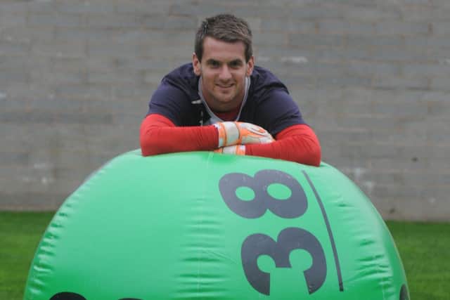 Tom Heaton with the giant National Lottery ball at the lauch of the new Lotto.
