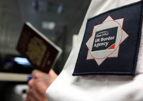 UK Border Agency officer checking a passport. Photo: Steve Parsons/PA Wire