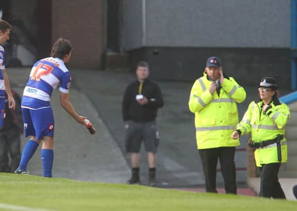 Joey Barton with the bottle that was thrown and hit him on the pitch.