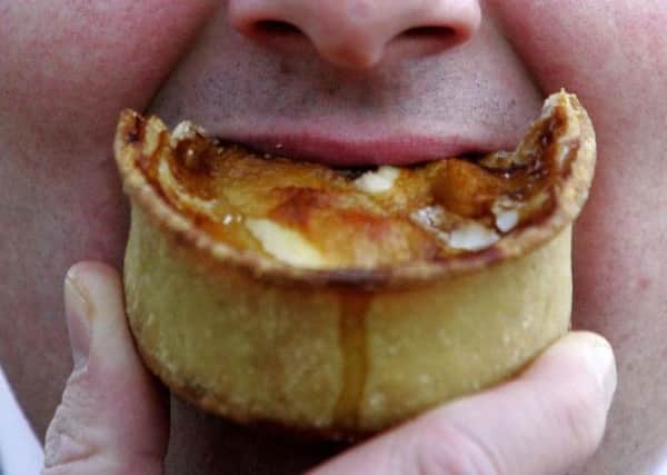 Man eating pie as diets laden with pies, sausages, and ready meals can lead to an early death. Photo: Andrew Milligan/PA Wire