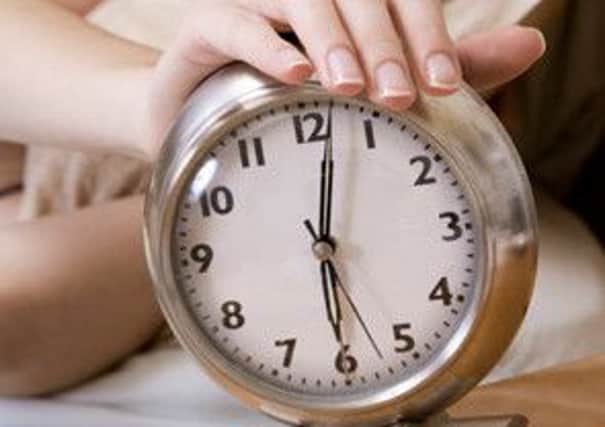 Woman in early waking up to an alarm clock