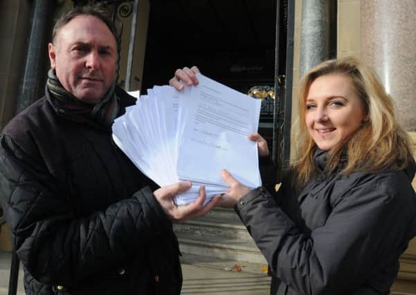 Coun. Jeff Sumner is presented with a petition with 533 names by Glebe Street community centre volunteer Jadene Christian over the closure of the centre.