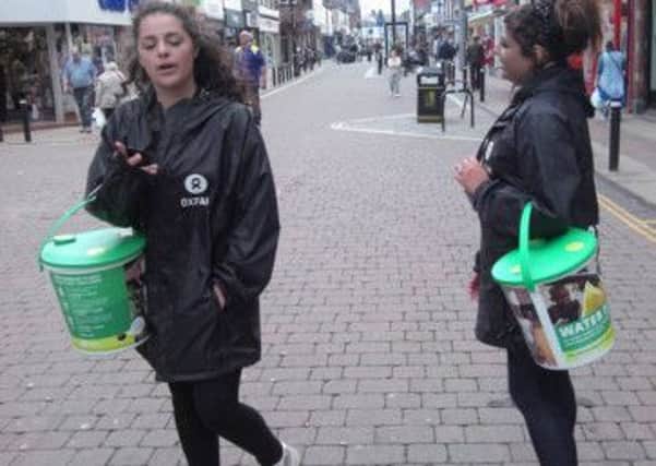 Chuggers holding collection buckets in Leigh town centre