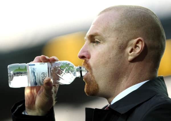 Keeping his cool: Clarets boss Sean Dyche reaches for some refreshment at Huddersfield Town on Saturday