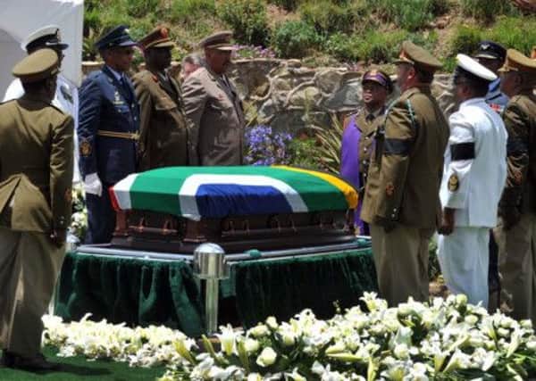 soldiers stand at attention over former South African President Madela's casket before his burial in his home village of Qunu, South Africa (AP Photo/Elmond Jiyane, CGIS)