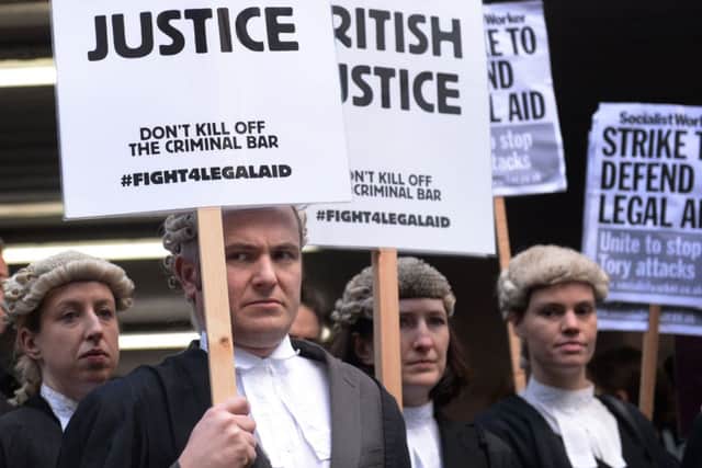 Barristers and solicitors outside Southwark Crown Court, London, during a nationwide strike against Government plans to cut fees as part of a bid to slash £220 million from the  legal aid budget by 2018/19. PRESS ASSOCIATION Photo. Picture date: Monday January 6, 2014. Barristers have chosen not to attend proceedings at courts in cities including London, Manchester, Liverpool, Leeds, Birmingham, Newcastle, Winchester, Bristol and Cardiff. Criminal Bar Association chair Nigel Lithman said the "strike" had the backing of almost every chambers and accused Justice Secretary Chris Grayling of "manipulating" official figures to falsely portray lawyers doing criminal aid work as high-earning "fat cats". See PA story POLITICS LegalAid. Photo credit should read: Stefan Rousseau/PA Wire