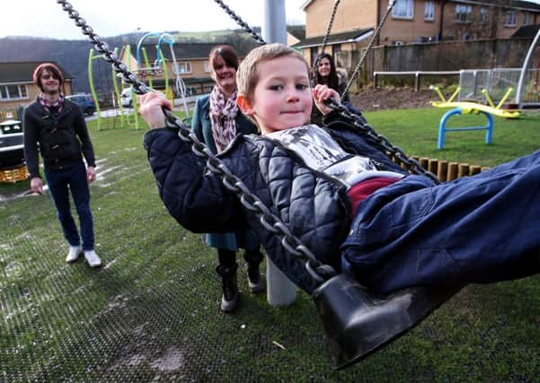 Harley Holmes plays on the swings in Todmorden