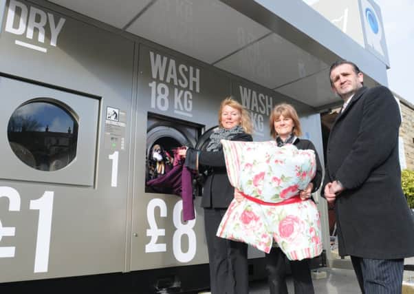Steve Robinson from Photo-Me along with Iris Hardacre and Tracy Atkinson get ready to load up the first outdoor 24 hour washing laundrette in the UK at Pendle Village Mill.