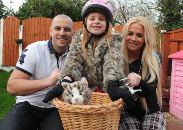 Television star Jolie Forrest with her parents Adam and Jodie on her bike that she rode in the advert.