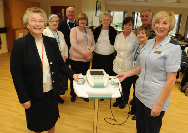 Chair of the League of Voluntary Workers Joan Carpenter, presents the new bladder scanner at the Rakehead Rehabilitation Centre to Sister Linda Hulmes.