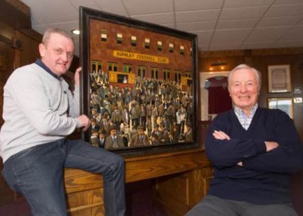 Paul Dacey hands the painting over to Burnley legend Jimmy McIlroy