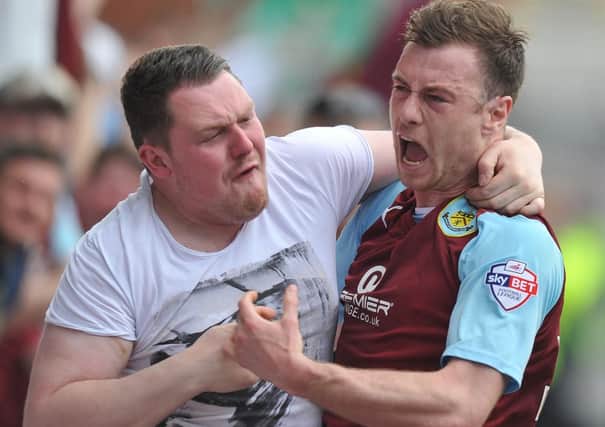 Burnley's Ashley Barnes celebrates scoring his team's first goal with a fan
