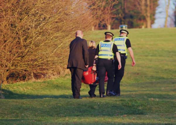 Hanging tragedy: The body is removed by police from woodland at Hard Platts.