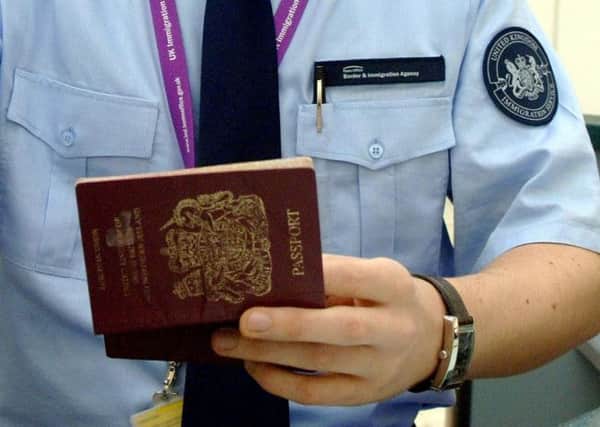 immigration officer checking a passport. Photo: Steve Parsons/PA Wire