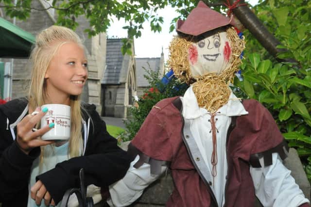 Higham Rose Queen Ellie Punchard (11) has a chat with Robin Hood at the Higham Scarecrow Festival.