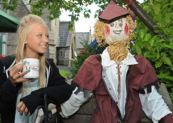 Higham Rose Queen Ellie Punchard (11) has a chat with Robin Hood at the Higham Scarecrow Festival.