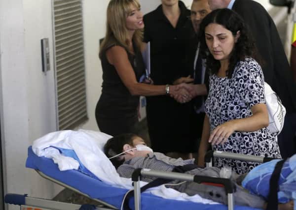 Naghemeh King, right, accompanies her son Ashya King, 5, as he arrives for pre-cancer treatment examinations at the Motol hospital in Prague, Czech Republic,(AP Photo/Petr David Josek)