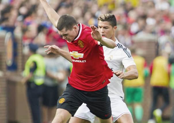 Michael Keane, front, gets challenged by Real Madrid forward Cristiano Ronaldo (7) for the ball in the second half of a Guinness International Champions Cup soccer match (AP Photo/Tony Ding)