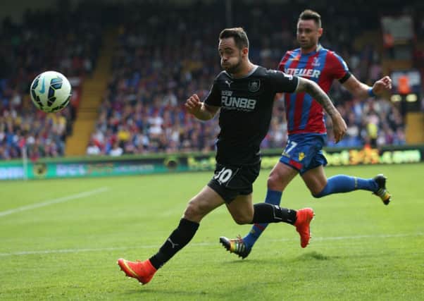 Injury worry: Striker Danny Ings, pictured bursting away from Damien Delaney, was forced off with a hamstring problem at Palace