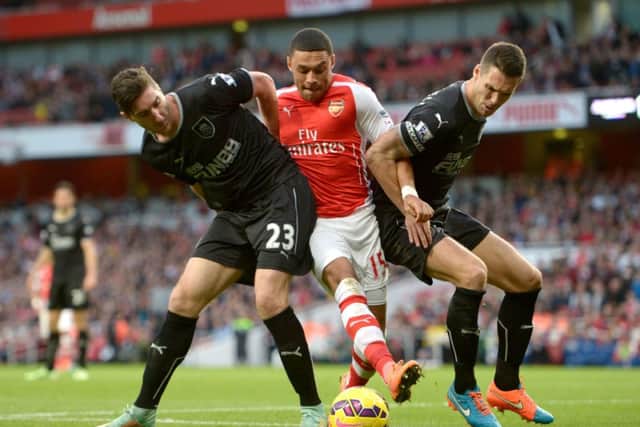 Arsenal's Alex Oxlade-Chamberlain (centre) battles for the ball with Burnley's Jason Shackell (right) and Burnley's Stephen Ward (left) during the Barclays Premier League match at the Emirates Stadium, London. PRESS ASSOCIATION Photo. Picture date: Saturday November 1st, 2014. See PA story SOCCER Arsenal. Photo credit should read Adam Davy/PA Wire. Editorial use only. Maximum 45 images during a match. No video emulation or promotion as 'live'. No use in games, competitions, merchandise, betting or single club/player services. No use with unofficial audio, video, data, fixtures or club/league logos.