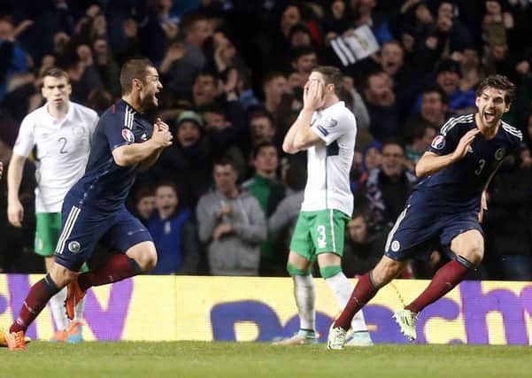 Stephen Ward (left) holds his head in his hands as Scotlands Charlie Mulgrew celebrates Shaun Maloneys winner at Celtic Park